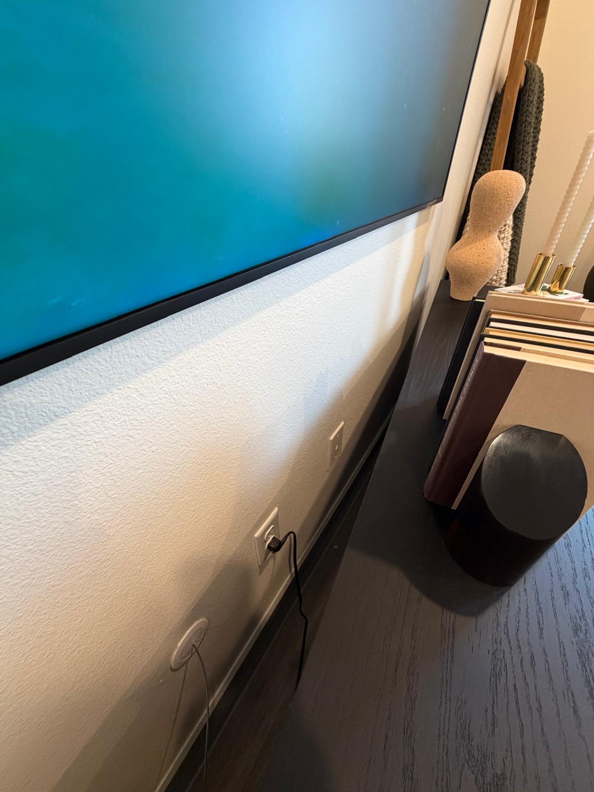The wired data drop below the wall-mounted TV, where the media panel cross-connect terminates