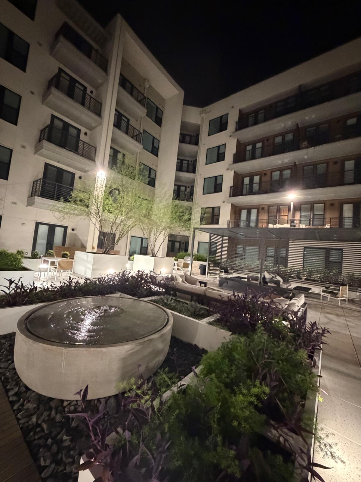 The courtyard water feature and lounge seating at night